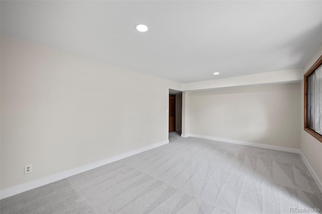 unfurnished room with recessed lighting, light carpet, and baseboards