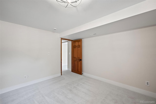 empty room featuring baseboards, visible vents, and light colored carpet