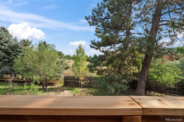 wooden deck with a fenced backyard