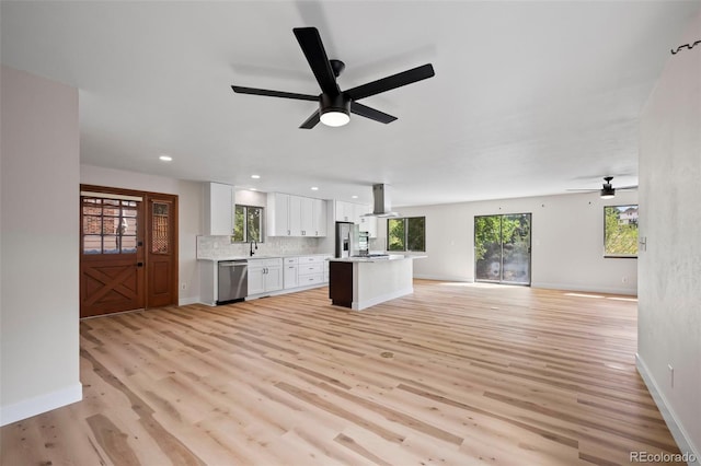 unfurnished living room featuring a ceiling fan, recessed lighting, baseboards, and light wood finished floors