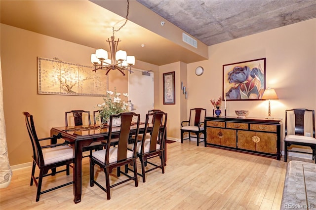 dining space featuring light wood-type flooring and a chandelier