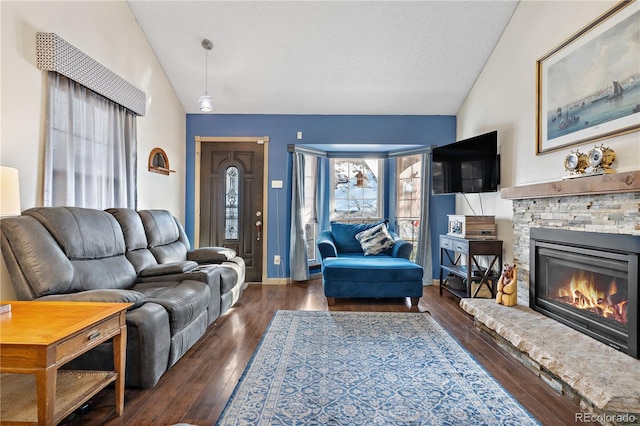 living room with a stone fireplace, dark hardwood / wood-style floors, and lofted ceiling