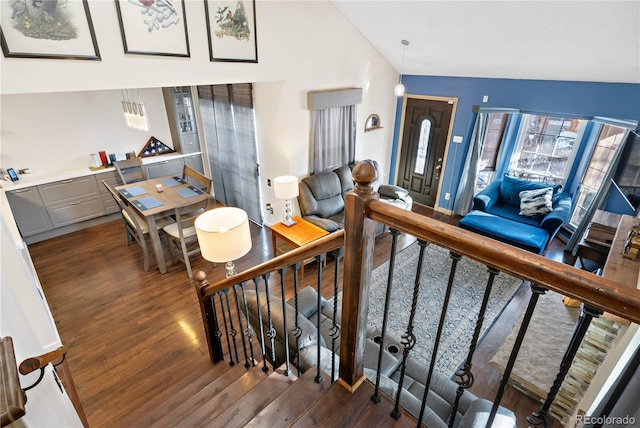 stairway featuring lofted ceiling and wood-type flooring