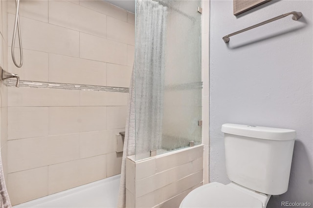 bathroom with a tile shower and toilet