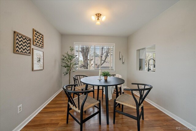 dining room with plenty of natural light, baseboards, and wood finished floors