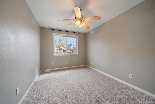 empty room featuring ceiling fan, light carpet, and baseboards