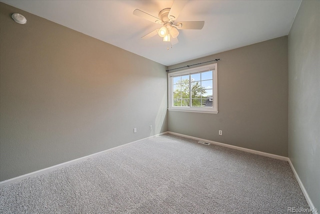 unfurnished room with carpet floors, a ceiling fan, a smoke detector, and baseboards
