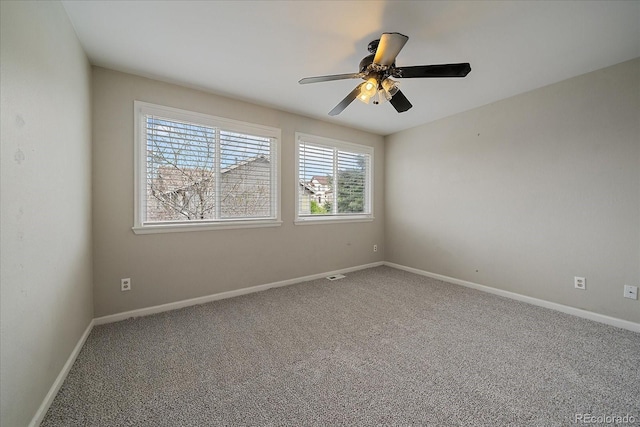 carpeted empty room featuring a ceiling fan and baseboards