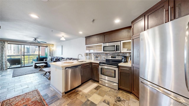 kitchen with stainless steel appliances, backsplash, sink, and dark brown cabinets