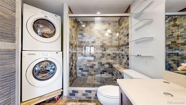 bathroom with toilet, a shower with door, and stacked washing maching and dryer