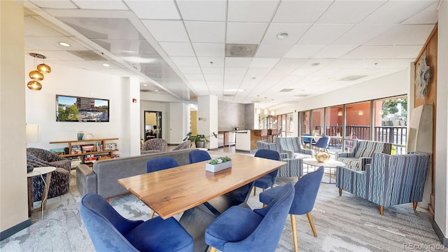 carpeted dining room featuring a drop ceiling