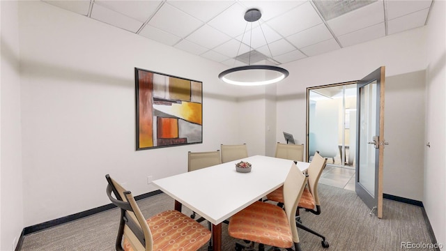 dining space with light colored carpet and a drop ceiling