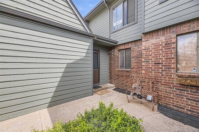 entrance to property featuring brick siding