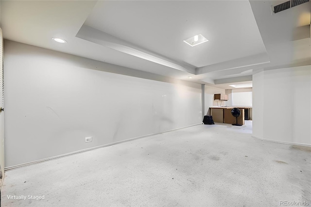 finished below grade area featuring baseboards, visible vents, and recessed lighting