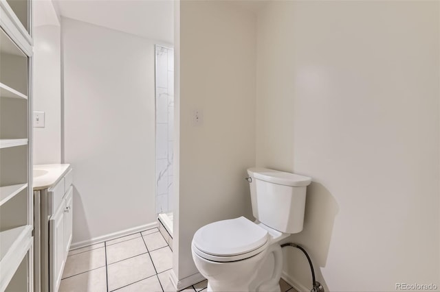 bathroom featuring toilet, vanity, tile patterned floors, a shower stall, and baseboards