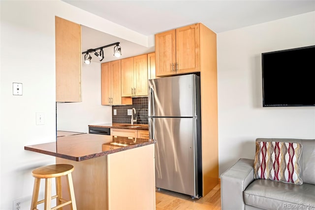 150 Evergreen Rd Unit 204, Dillon, CO 80435 - kitchen with freestanding refrigerator, dark countertops, a sink, light brown cabinetry, and backsplash