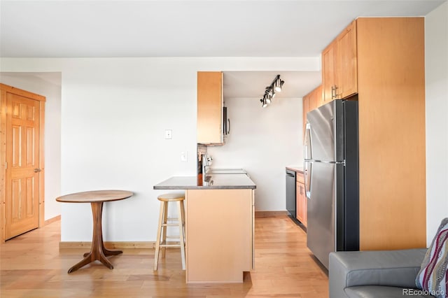 150 Evergreen Rd Unit 204, Dillon, CO 80435 - kitchen with stainless steel appliances, light wood-style flooring, a kitchen breakfast bar, a peninsula, and rail lighting