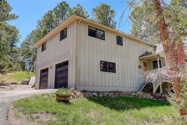 8795 Rudd Rd, Evergreen, CO 80439 - view of side of home featuring an attached garage, driveway, and board and batten siding