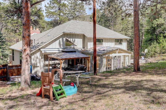 8795 Rudd Rd, Evergreen, CO 80439 - rear view of house with a shingled roof, a chimney, board and batten siding, and fence