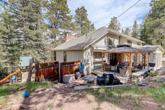 8795 Rudd Rd, Evergreen, CO 80439 - rear view of property with a gazebo, a chimney, fence, board and batten siding, and a playground