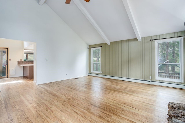 8795 Rudd Rd, Evergreen, CO 80439 - unfurnished living room with beamed ceiling, plenty of natural light, wood finished floors, ceiling fan, and high vaulted ceiling