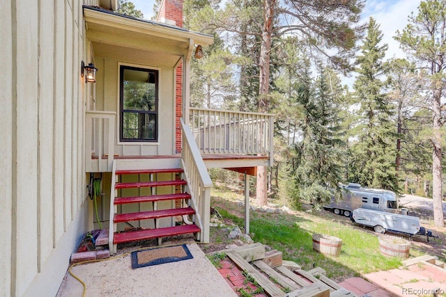 8795 Rudd Rd, Evergreen, CO 80439 - property entrance featuring a wooden deck and a chimney