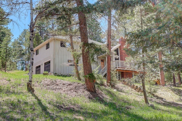 8795 Rudd Rd, Evergreen, CO 80439 - view of side of home featuring stairway, a garage, a deck, and a chimney