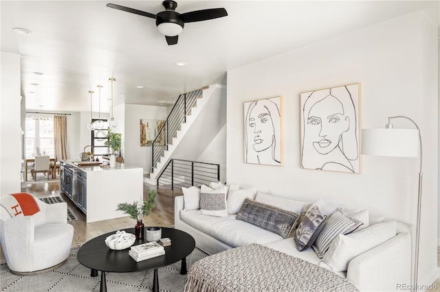 living room with ceiling fan, light hardwood / wood-style flooring, and sink