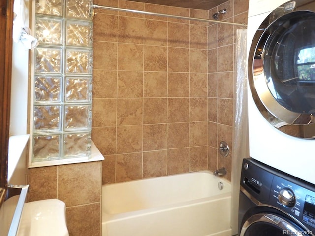 full bathroom featuring tiled shower / bath, vanity, toilet, and stacked washing maching and dryer