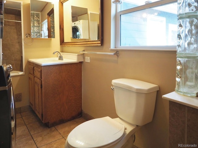 bathroom featuring a tile shower, tile patterned floors, vanity, and toilet