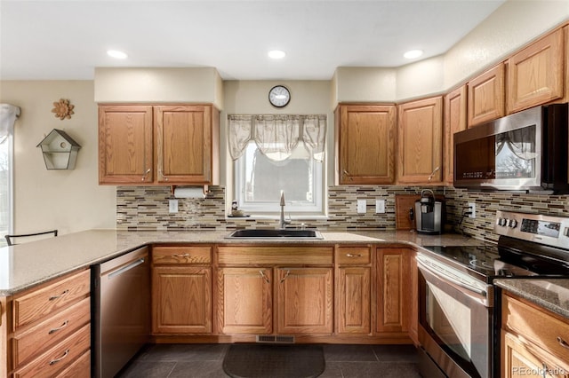 kitchen featuring sink, decorative backsplash, dark tile patterned floors, and appliances with stainless steel finishes