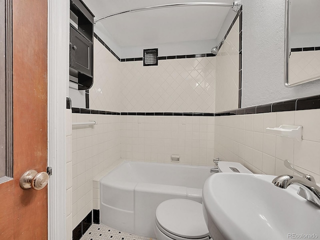 bathroom with toilet, a sink, a tub to relax in, tile walls, and walk in shower