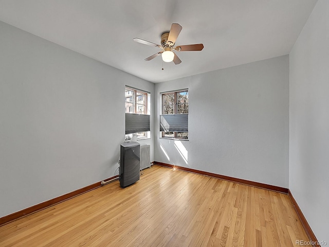 unfurnished room with baseboards, ceiling fan, and radiator heating unit