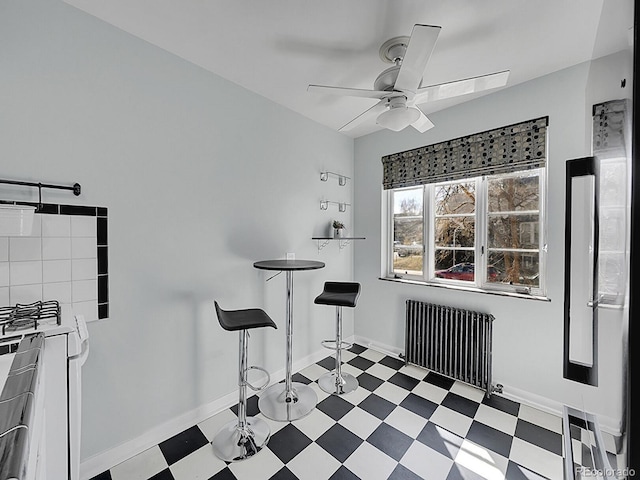 dining room featuring ceiling fan, radiator, baseboards, and tile patterned floors