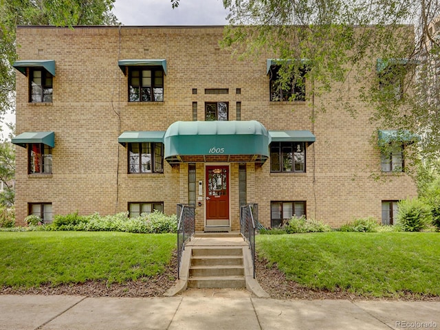 view of front of home featuring brick siding and a front yard