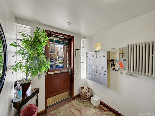 doorway featuring radiator, baseboards, and mail area