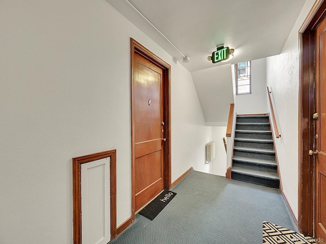 stairway with vaulted ceiling, carpet flooring, and baseboards