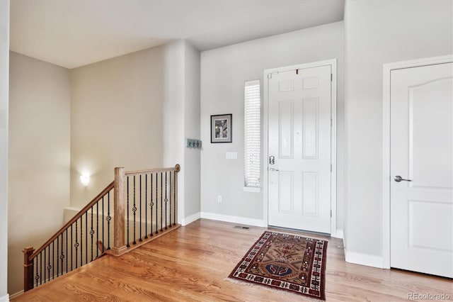 foyer with visible vents, baseboards, and wood finished floors