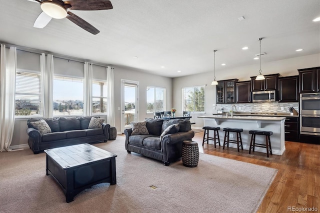 living room featuring recessed lighting, baseboards, ceiling fan, and dark wood-style flooring