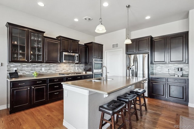 kitchen with visible vents, a kitchen breakfast bar, appliances with stainless steel finishes, and dark wood finished floors