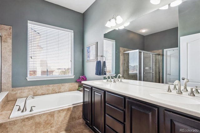 full bath featuring a sink, a garden tub, and a stall shower