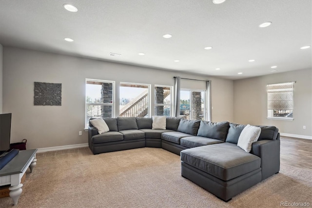 living area featuring light colored carpet, recessed lighting, and baseboards