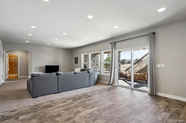 living room with arched walkways, recessed lighting, and wood finished floors