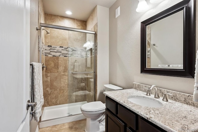 full bathroom with visible vents, toilet, a stall shower, and vanity