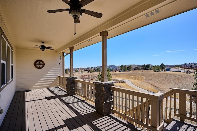 wooden terrace with visible vents and a ceiling fan