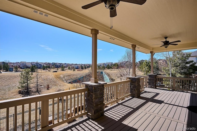 wooden terrace with a ceiling fan and visible vents