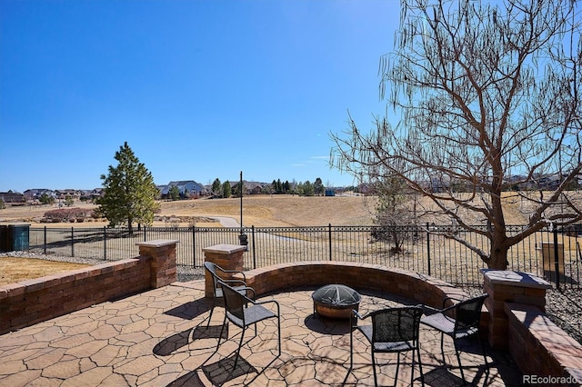 view of patio featuring an outdoor fire pit and fence