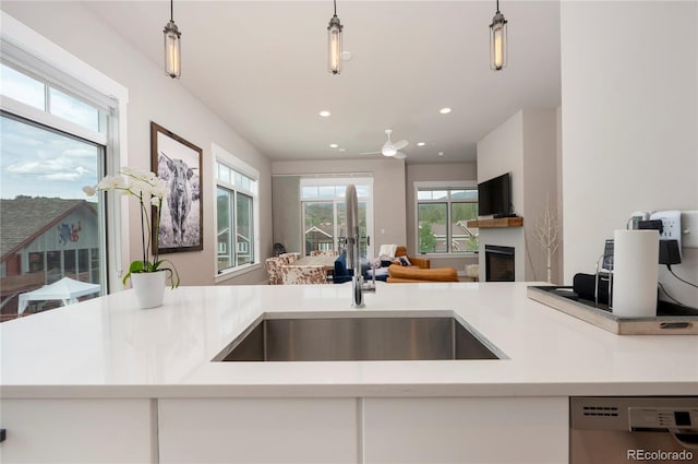 kitchen with dishwashing machine, pendant lighting, and sink