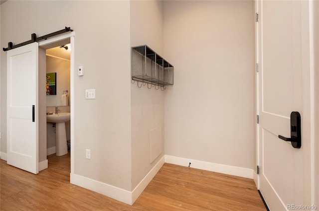 corridor featuring hardwood / wood-style floors, a barn door, and sink