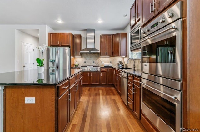 25402 E Glasgow Pl, Aurora, CO 80016 - kitchen featuring wall chimney exhaust hood, appliances with stainless steel finishes, wood finished floors, backsplash, and a center island